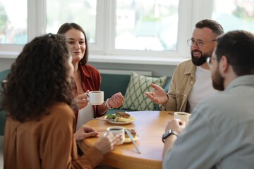 Colleagues chatting during lunch break in office