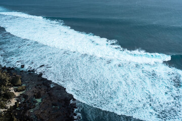 The texture of the crashing waves on the coral beach with blue sea water