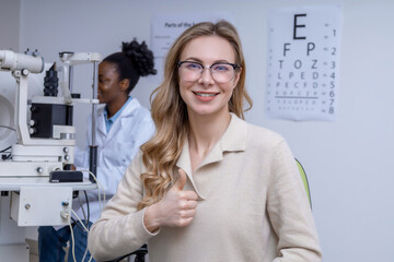Blonde pretty young woman in new eyeglasses at the optometrist office