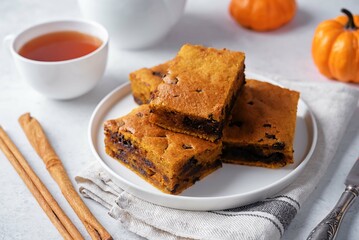Pumpkin cake with chocolate filling in a plate on a white background