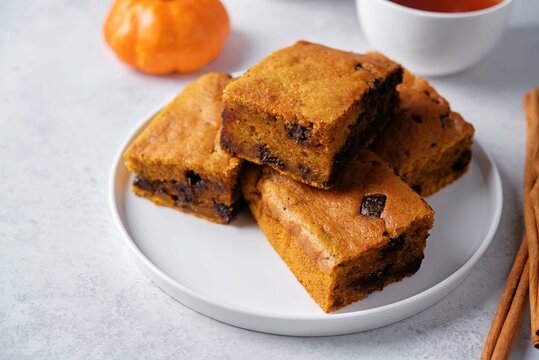 Pumpkin cake with chocolate filling in a plate on a white background