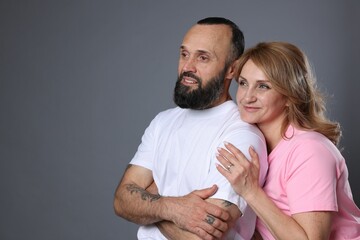 Portrait of lovely couple on grey background, space for text
