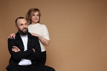Portrait of lovely couple on brown background, space for text