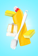 Toilet brush and other cleaning supplies in air on light blue background