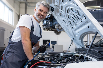 Mechanic with toolbox and laptop in workshop