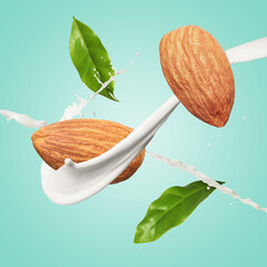 Nut milk splash, almonds and green leaves in air on turquoise background