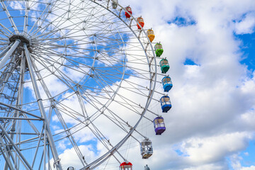 Colourful ferris wheel against a blue sky.