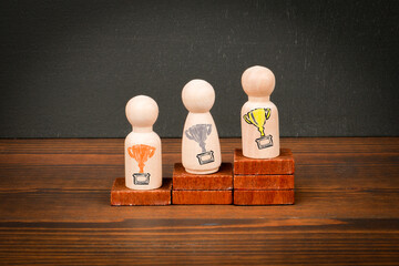 Wooden Figures on Podium Representing First, Second, and Third Place with Trophy Symbols