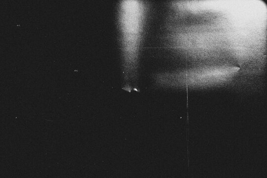 retro film overlay effect with scratch dust and light leaks,retro grain noisy film distressed texture light leak flare on black background	