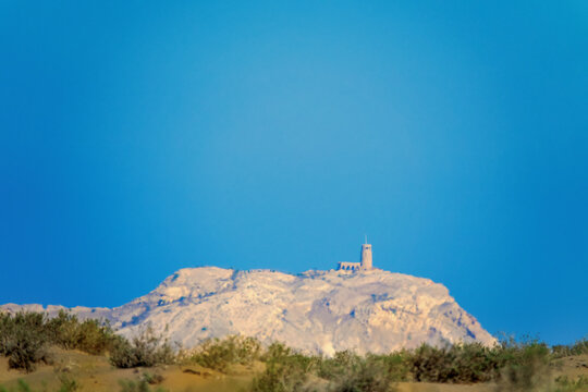 A mirage, ghostly vision, heat devils, sultry air, blur. Ancient white tower on white rock in haze of desert resembles Fata Morgana. It's like something out of Arabic fairy tale. Oman