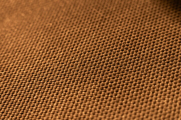 Close-up texture of textile surface. Extreme macro close-up of synthetic fabric surface. Gold background in shallow depth of field