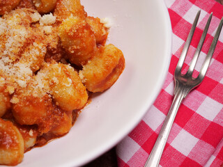 Primo piano di piatto di gnocchi al ragù con parmigiano 