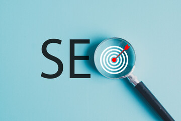 SEO Search Engine Optimization word and  Target icon  under Magnifying Glass on light blue background use for Digital Marketing Strategy, Business Goals, Analytics, and Success Focus concept.