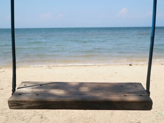 wooden swing with blue sea background, suitable for health products, lifestyle, relaxation, fresh drinks, frozen desserts,