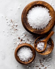 Sea salt crystals in wooden bowls with spoon overhead studio shot culinary ingredient seasoning spice flavor enhancer