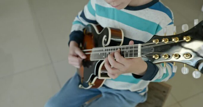 Caucasian Kid Play Mandolin at Home. European Boy Practice Music 4K 10-bit
