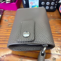 Detailed view of a small gray leather wallet with zipper closure