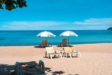 Tropical beach and sea with fresh summer sky on Koh Samui. Beach chairs and umbrellas. Seaside vacation. Summer getaway.