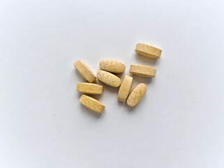 A pile of yellow pills on a white background