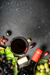 Glass of wine, bottle and fresh crape on black.