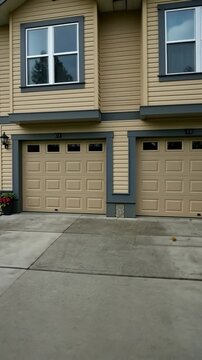 A duplex with a shared driveway and individual garages, ideal for multi-family living in an urban setting..