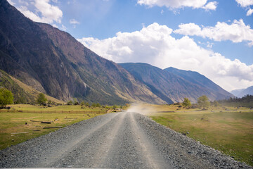 Fototapeta premium Dirt road running along Chulyshman river at entrance to Chulyshman valley in Altai Russia Scenic remote route through wild mountain landscape
