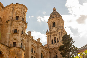 Fototapeta premium Santa Iglesia Catedral Basilica. Historic architecture featuring ornate details and a towering bell tower under a bright blue sky with fluffy clouds