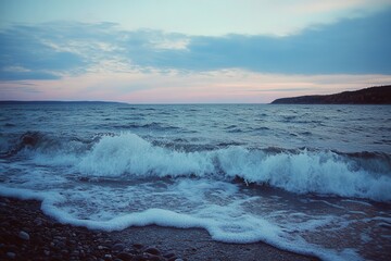 Fototapeta premium Wave breaking on shore at dusk on a white background