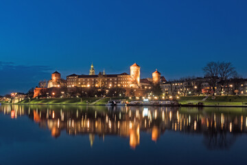 Die historische Wawelburg spiegelt sich zur blauen Stunde im Wasser des Flusses Weichsel, Krakau, Polen
