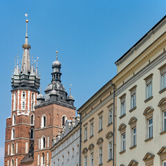 Außenansicht historischer Häuser und der beiden Türme der historischen Backsteinkirche St. Marien in Krakau, Polen