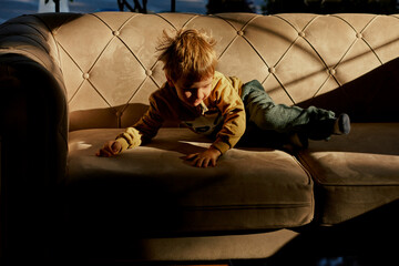 Little caucasian boy is playing in the hotel lobby by himself.