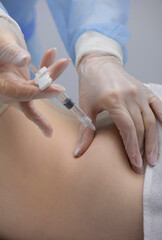 Physiotherapist doing an injection to the back of a patient