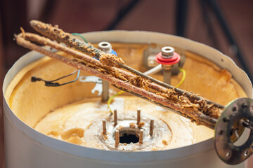 Corrosion and mineral deposits on the heating element of an electric boiler. Boiler maintenance and repair