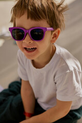 Little cute boy in the sunglasses enjoying summer on the sun bed in hotel of Turkey.