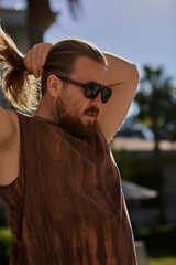 Man holding his hair in the sunlight