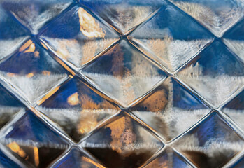 Abstract macro of backlit cut glass, blue and gold and beige