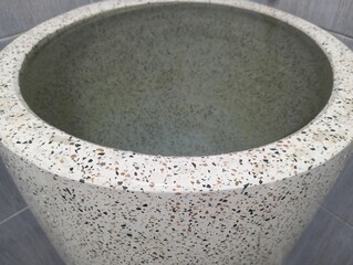 Granite water tank with grey tile background in the bathroom