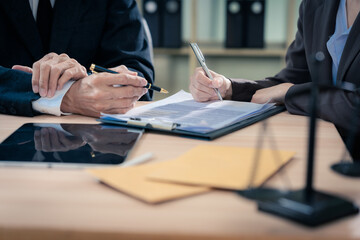Law office with legal books and scales on table. Legal consultation: lawyer and client reviewing...