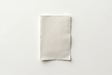 Blank piece of textured paper lies on clean, white background, showcasing its subtle surface and edges. This minimalist composition highlights simplicity and elegance of material