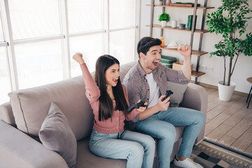 Obraz premium Young couple enjoying time together playing video games in a bright modern living room, showcasing fun