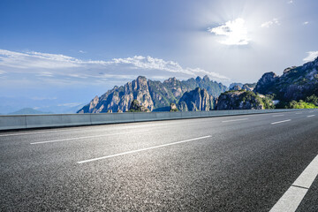 Empty asphalt road and mountain with beautiful sky clouds on a sunny day