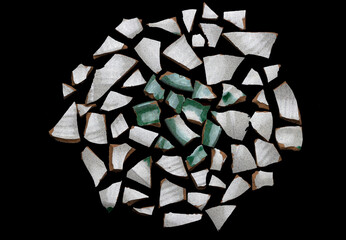 Scattered Ceramic Shards on Black Background