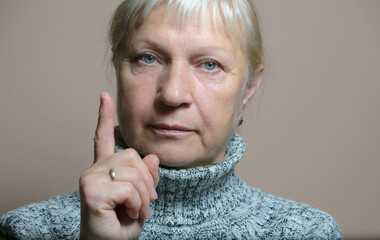 Middle aged woman portrait. Gesturing with index finger.