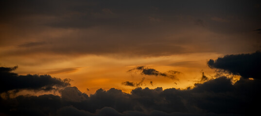 Sunset sky with dark orange clouds. Nature background.