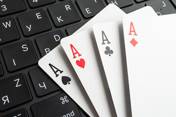 A close-up of five playing cards against a blurred office background, symbolizing gaming and work environment