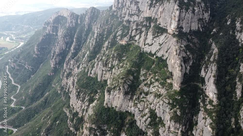 Poster dramatic side view of montserrat’s sharp cliffs and terrain in drone video