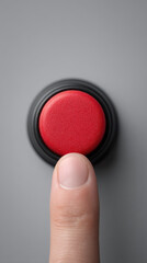 Finger pressing red button on gray surface, close up view