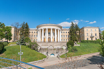 Neoclassical building with columns, pediments, numerous windows, and a stone facade Landscaped...