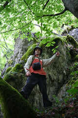 Hiker Exploring Mossy Cliffside on Olympus Mountain
