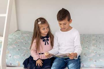 Cute Brother Reading Book to Younger Sister on Bed – Childhood Learning, Sibling Bond, Early Education, and Indoor Family Moments